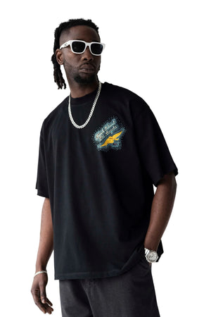 Man wearing a black t-shirt with a graphic design on a plain background