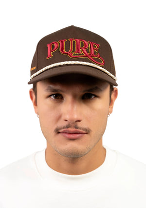 Man wearing a brown cap with 'PURE' text on a white background