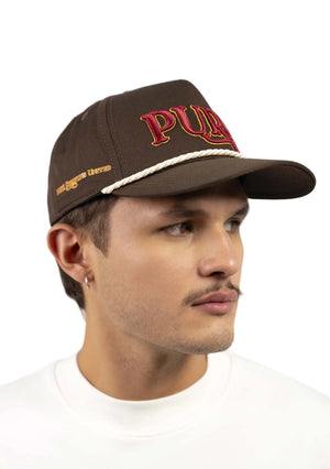 Man wearing a brown cap with 'Puma' branding against a plain background