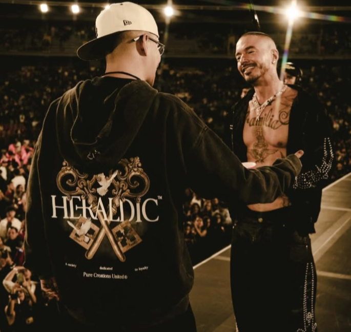 Two men in a crowd with one wearing a 'Heraldic' jacket. Pure Worldwide