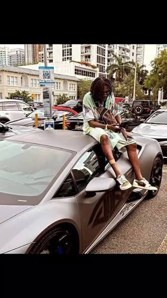 Vibez Cartel sitting on a car in an urban setting